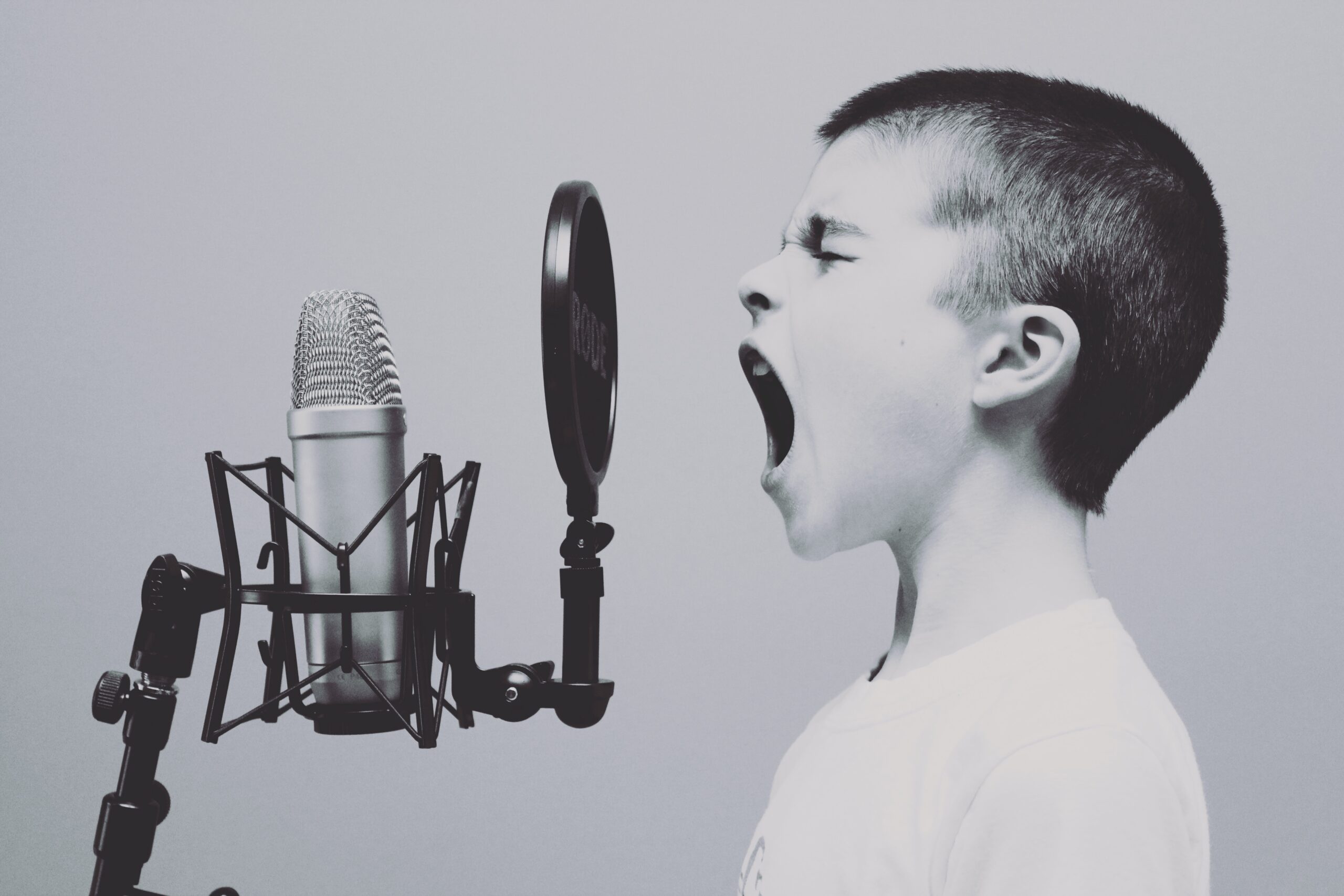 Bambino espressivo che canta al microfono